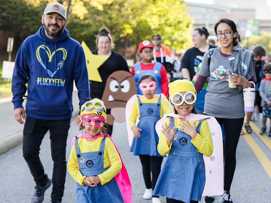 Families in costume enjoying an A Kid Again adventure walk event.
